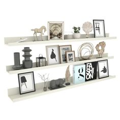 three white shelves filled with pictures and other items on top of each shelf in front of a white wall