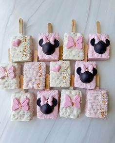 decorated cookies with minnie mouse ears and bows are arranged in rows on a white surface