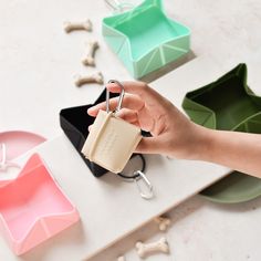 a person is holding a keychain in front of some dog bones and bowls