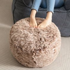 a person sitting on a bean bag chair with their feet in the top of it