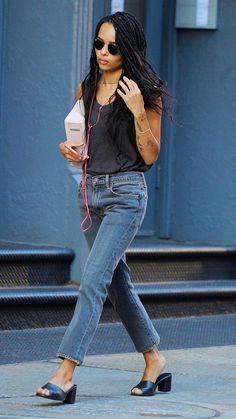 a woman walking down the street while listening to her cell phone