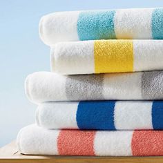 four towels stacked on top of each other in different colors and patterns, all folded up