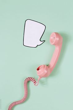 an old pink telephone with a speech bubble attached to the cord by paul jackson for stockstation