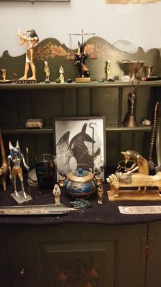 an assortment of figurines and other items on a table in front of a shelf