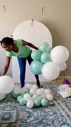 a woman standing in front of balloons on top of a bed