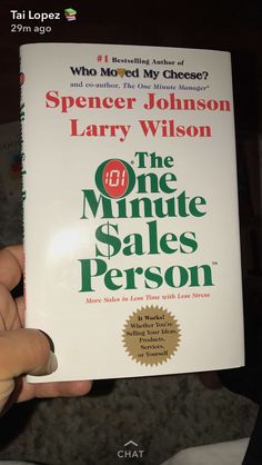 a person holding up a copy of the one minute sales person by spencer johnson