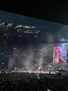 a concert with confetti thrown in the air and people standing on the stage