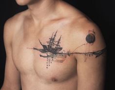 a man's chest with a ship tattoo on it