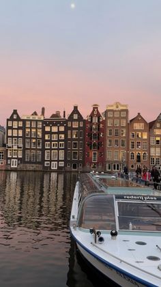 a boat is docked in the water next to some buildings