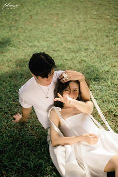 a man and woman sitting on the grass together