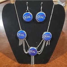 a necklace and earring set with the logo of an electronic company on it, sitting on a display stand