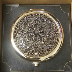 an ornate gold pocket watch in a box