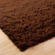 a brown shaggy rug sitting on top of a wooden floor