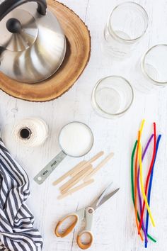 various crafting supplies laid out on a white wooden table with scissors and other items