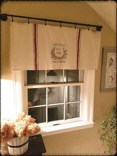 a kitchen window with a potted plant in front of it and an old fashioned sign above the window