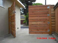 an open wooden gate in front of a house