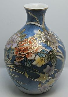 a blue vase with flowers painted on it