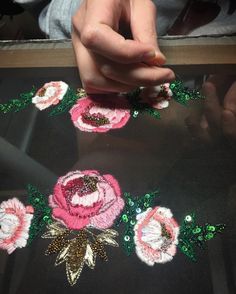 someone is working on some flowers with sequins and beadwork in the shape of roses