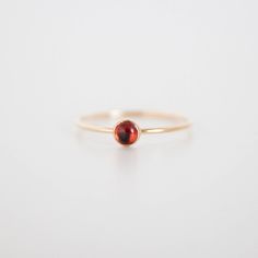 This is a ring with attitude. Featuring moody deep red garnets, the Garnet Ring is a statement-maker and subtle pop at the same time. P.S. Garnets are the January birthstone! Maybe we're biased, but we think birthstone jewelry makes a perfect gift. Explore more birthstone rings and necklaces here. Details Band is 1mm thick, stone is 4mm Gold fill or sterling silver Whole and half sizes: US 3-14 (message us for smaller or larger sizes) See this page for ring sizing + conversions. Red Garnet Ring, Birthstone Rings, January Birthstone, Garnet Ring, Garnet Rings, Red Garnet, Birthstone Ring, Birthstone Jewelry, Deep Red