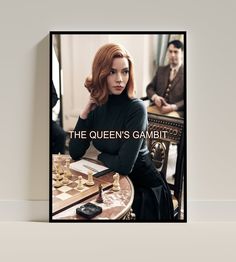 the queen's gambit poster is displayed on a table