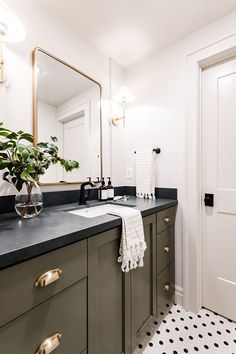 a bathroom with a sink, mirror and plants in the vase on the counter top