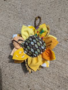 a close up of a flower on the ground with other fabric items around it and an umbrella in the background