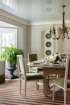 the dining room table is set with green chairs