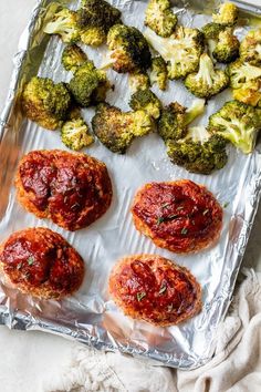 broccoli and other food items on aluminum foil lined up on a white surface