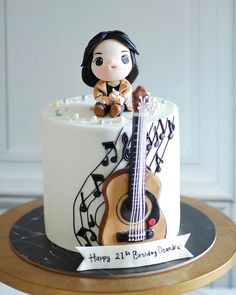 a birthday cake with a doll on top of it and music notes in the background