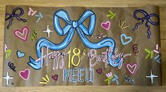 a brown birthday card with blue ribbon and hearts