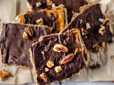 a white plate topped with pieces of chocolate covered crackers and nuts on top of it