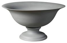 a large white bowl sitting on top of a wooden stand in front of a white background