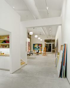 the interior of an art gallery with white walls and flooring, including bookshelves