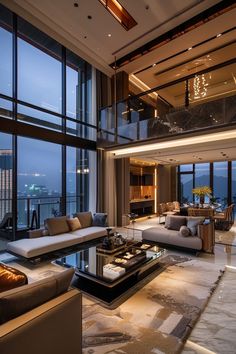 a living room filled with lots of furniture and large windows overlooking the city at night