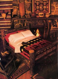 a bedroom with a bed, fireplace and pictures on the wall above it is decorated in native american style