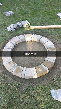 an outdoor fire pit with the words first row written on it and tools laying around