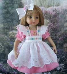 the doll is wearing a pink and white dress