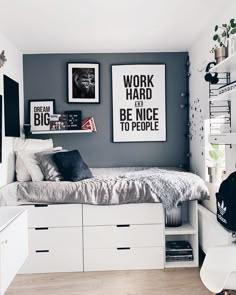 a bedroom with white and gray walls, pictures on the wall