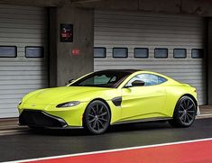 a yellow sports car parked in front of garage doors