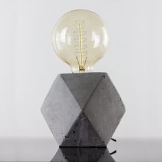 a light bulb sitting on top of a cement block with a glass ball in the middle