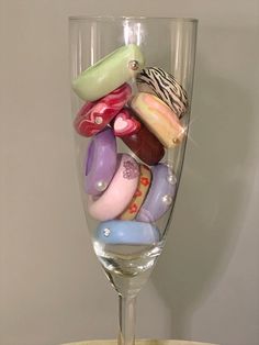 a wine glass filled with lots of different colored candies