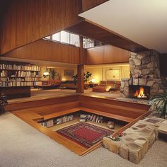 a living room filled with furniture and a fire place in the middle of an open floor plan