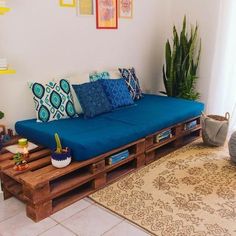 a couch made out of wooden pallets in a living room next to a rug