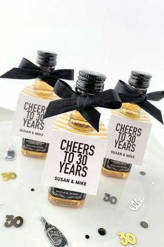 three bottles of cheer's to 30 years on a plate with confetti