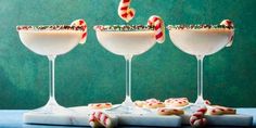 three glasses filled with candy canes on top of a table