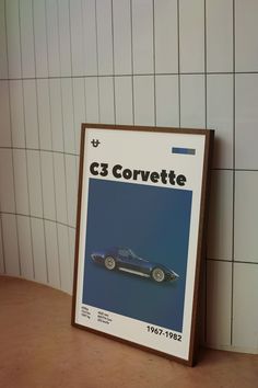 a car advertises the c3 corvette in front of a white tiled wall