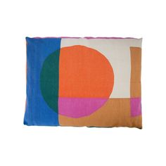 an orange, pink, blue and green pillow with circles on it's side