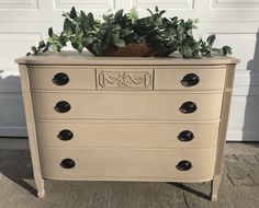 an old dresser has a potted plant sitting on it's top and bottom