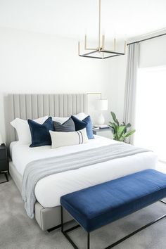 a bed with blue and white pillows in a bedroom