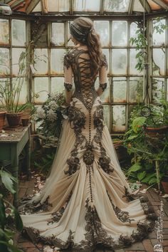 a woman standing in front of a window wearing a dress with flowers on the back